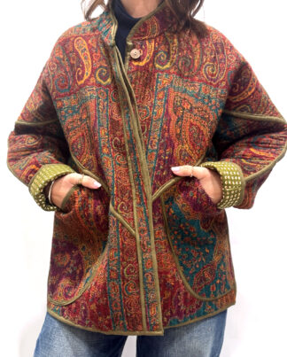 La Veste Iska, une veste en laine réversible aux imprimés de couleurs foncées : kaki, bordeaux, orange et des touches de bleus.