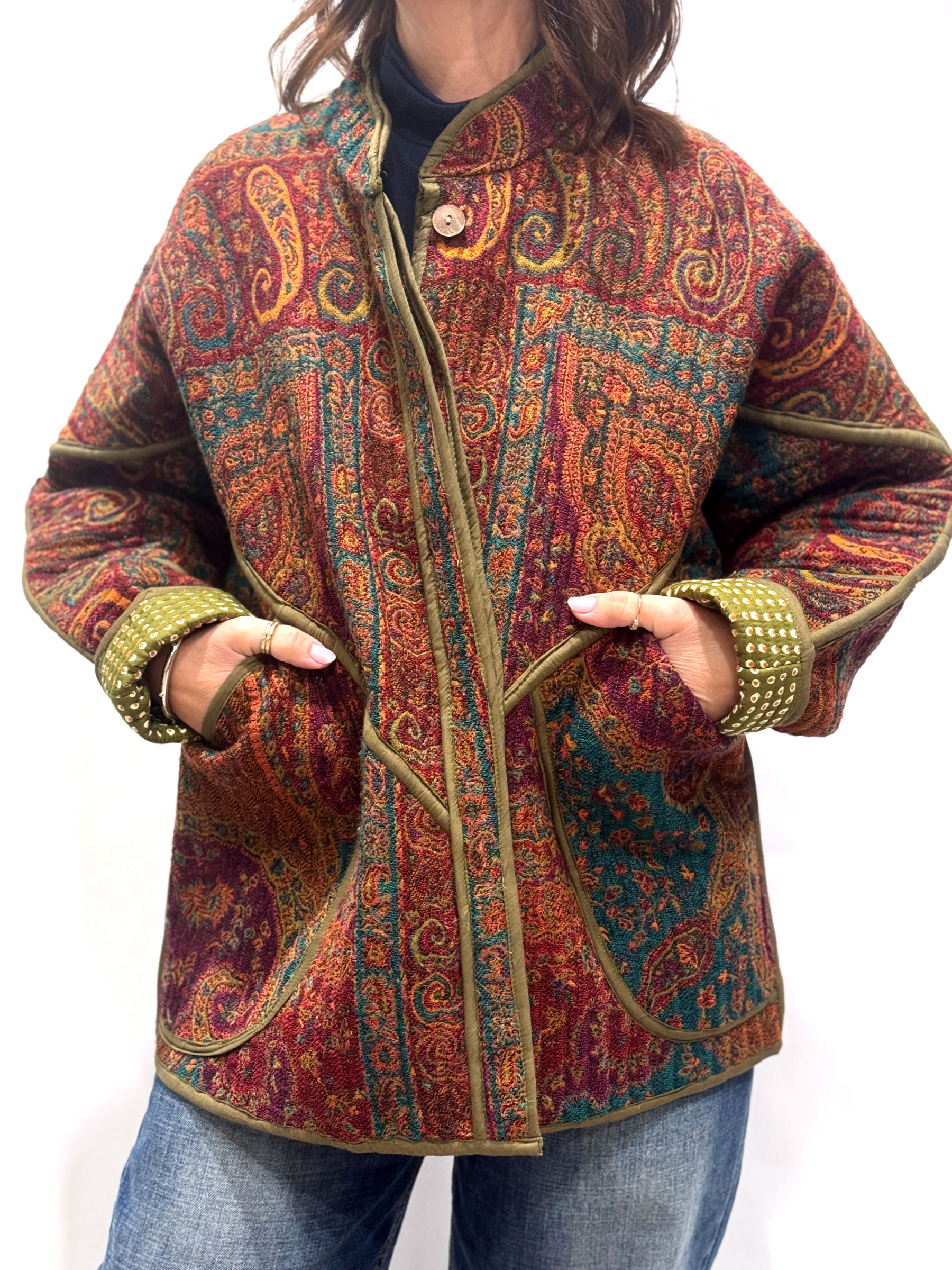 La Veste Iska, une veste en laine réversible aux imprimés de couleurs foncées : kaki, bordeaux, orange et des touches de bleus.