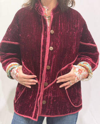 La veste Alba, une veste en velours de soie réversible. Une veste burgundy, et à l'intérieur un imprimé vert et burgundy avec des motifs.