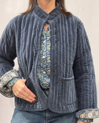 La veste Azura, une veste en velours bleu. Une veste col mao réversible, en coton imprimé à l'intérieur, bleu et blanc avec des motifs floraux. Une veste parfaite pour la mi saison.