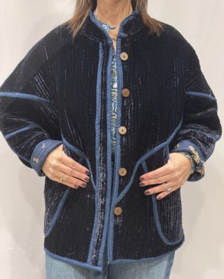 La veste Azuro, une veste en velours de soie réversible. Une veste bleu marine, et à l'intérieur un imprimé bleu marine avec des motifs de jaguars et palmiers.