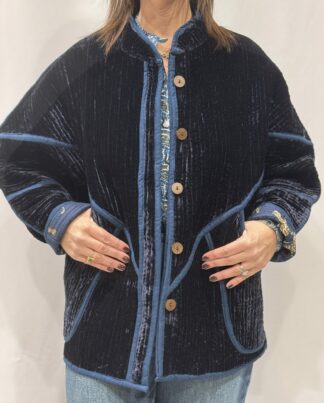 La veste Azuro, une veste en velours de soie réversible. Une veste bleu marine, et à l'intérieur un imprimé bleu marine avec des motifs de jaguars et palmiers.