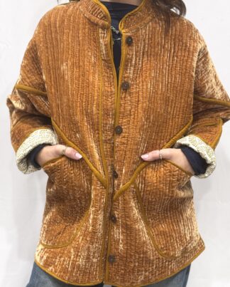 La veste Davia, une veste en velours de soie réversible. Une veste orange clair, et à l'intérieur un imprimé blanc et orange avec des motifs.