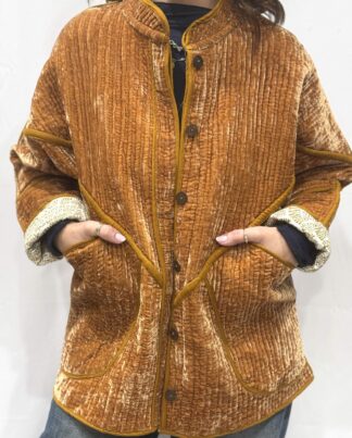 La veste Davia, une veste en velours de soie réversible. Une veste orange clair, et à l'intérieur un imprimé blanc et orange avec des motifs.