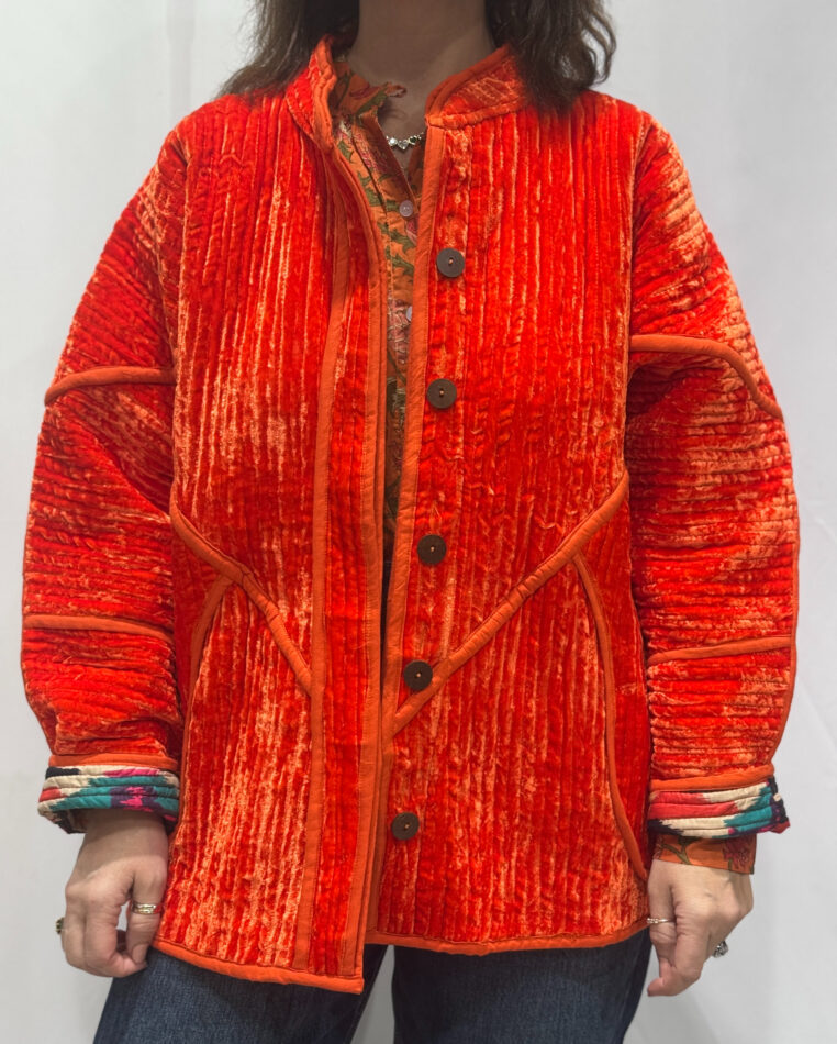 La veste Diyha, une veste en velours de soie réversible. Une veste orange, et à l'intérieur un imprimé ikat avec des motifs.