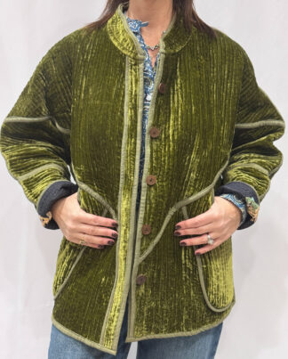 La veste Nalini, une veste en velours de soie réversible. Une veste vert kaki, et à l'intérieur un imprimé noir avec des motifs.