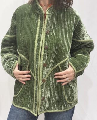 La veste Ojavi, une veste en velours de soie réversible. Une veste verte claire, et à l'intérieur un imprimé bleu avec des motifs jungle.