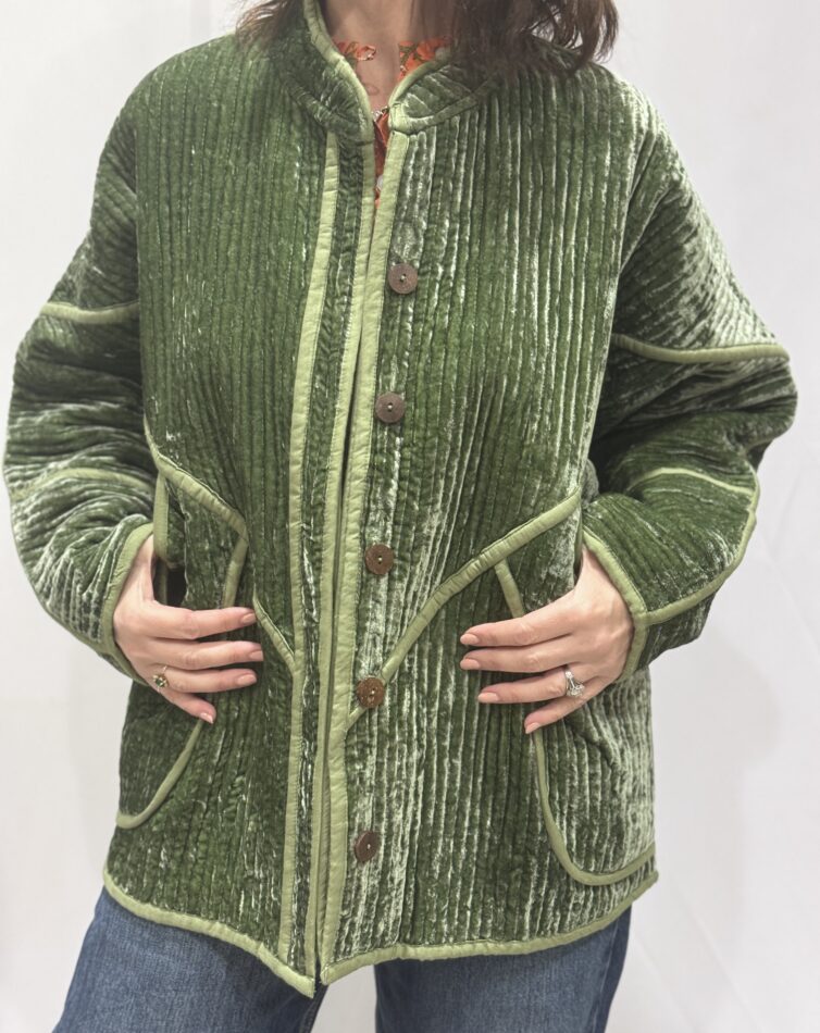 La veste Ojavi, une veste en velours de soie réversible. Une veste verte claire, et à l'intérieur un imprimé bleu avec des motifs jungle.