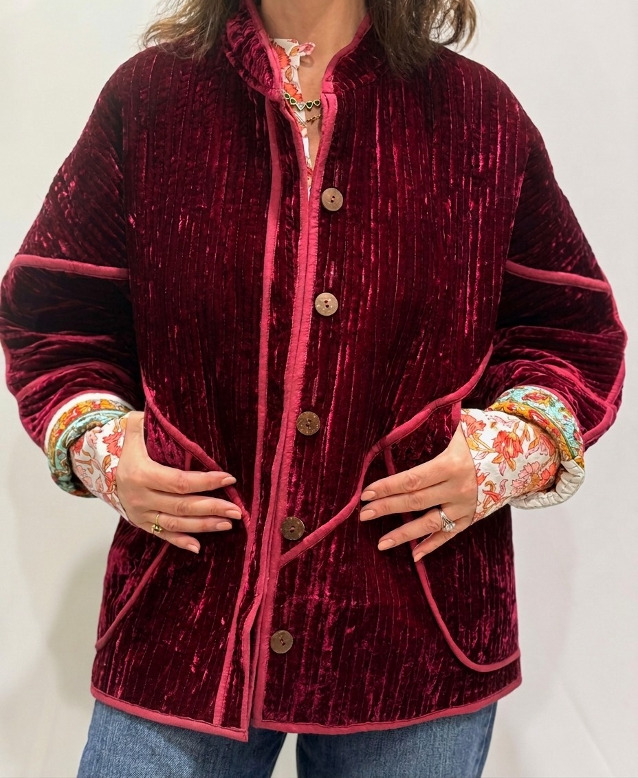 La veste Alba, une veste en velours de soie réversible. Une veste burgundy, et à l'intérieur un imprimé vert et burgundy avec des motifs.