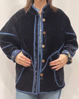 La veste Azuro, une veste en velours de soie réversible. Une veste bleu marine, et à l'intérieur un imprimé bleu marine avec des motifs de jaguars et palmiers.