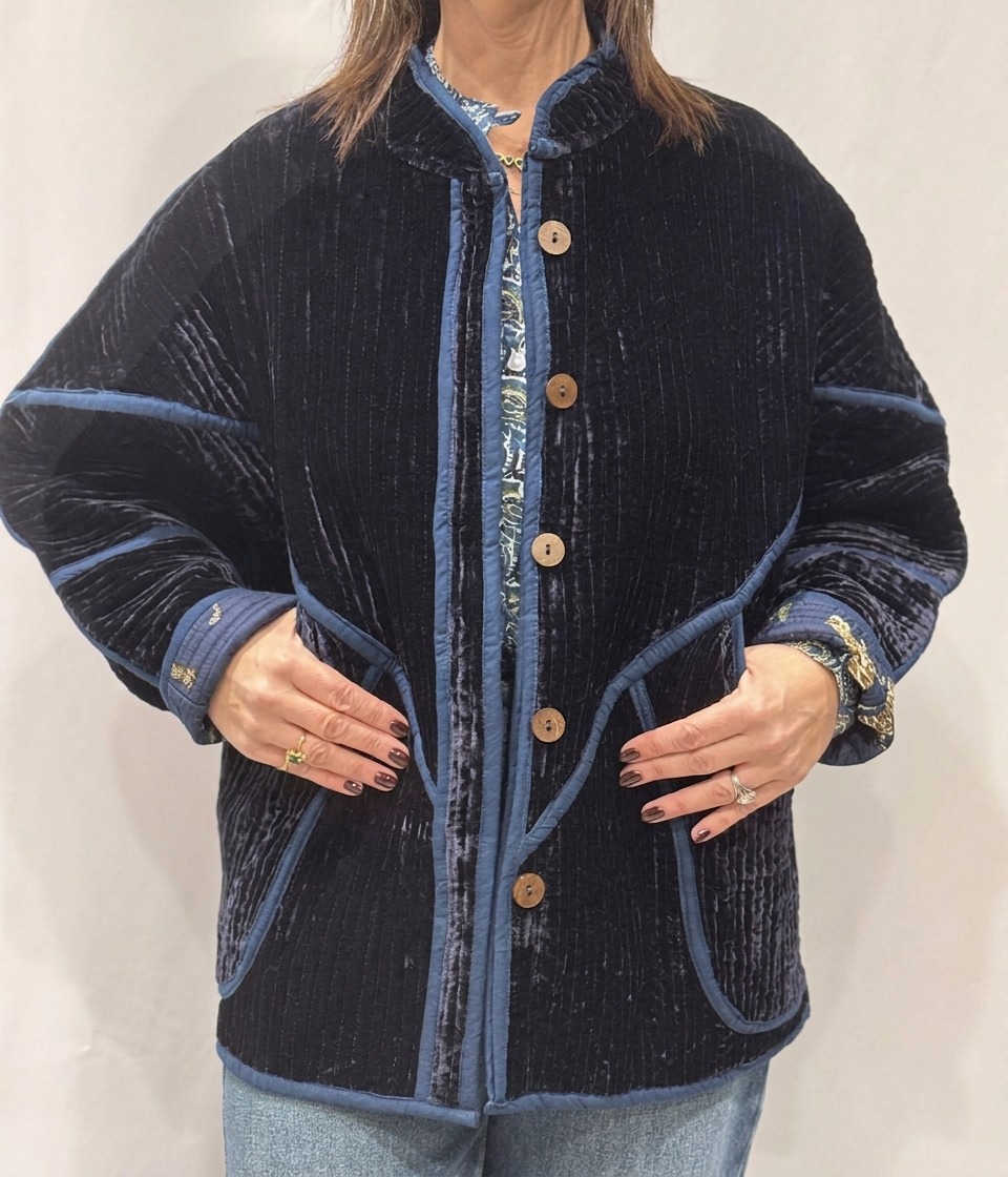 La veste Azuro, une veste en velours de soie réversible. Une veste bleu marine, et à l'intérieur un imprimé bleu marine avec des motifs de jaguars et palmiers.