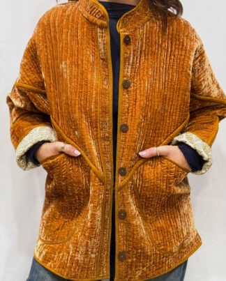 La veste Davia, une veste en velours de soie réversible. Une veste orange clair, et à l'intérieur un imprimé blanc et orange avec des motifs.
