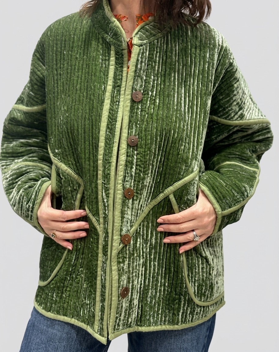 La veste Ojavi, une veste en velours de soie réversible. Une veste verte claire, et à l'intérieur un imprimé bleu avec des motifs jungle.