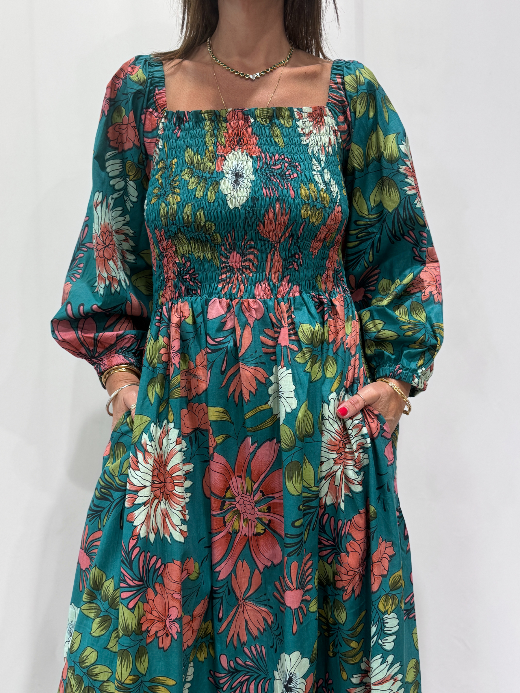 Robe Amira Bleue, une robe longue smockée. Fluide et 100 % coton. Elle est de couleur bleue avec des imprimée fleurit.