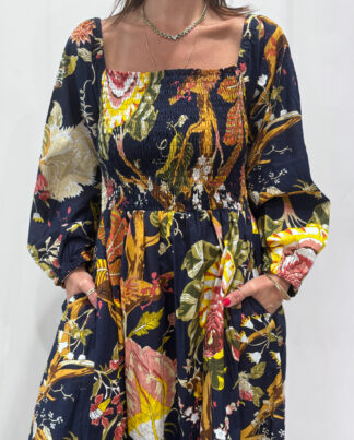 Robe Amira Bleue Marine une robe longue smockée. Fluide et 100 % coton. Elle est de couleur bleue marine avec des imprimée fleurit.