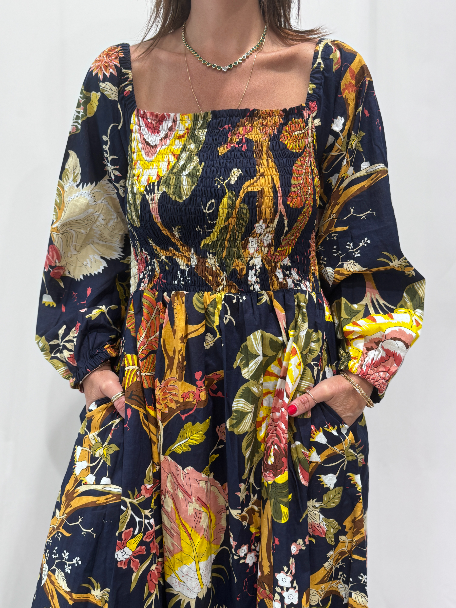 Robe Amira Bleue Marine une robe longue smockée. Fluide et 100 % coton. Elle est de couleur bleue marine avec des imprimée fleurit.
