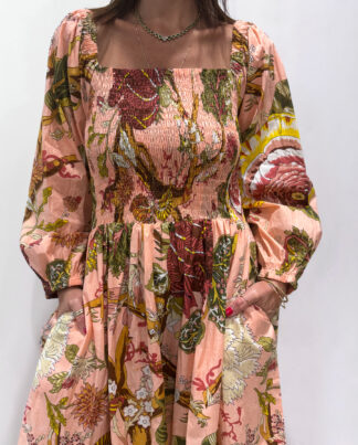 Robe Amira Rose Pâle, une robe longue smockée. Fluide et 100 % coton. Elle est de couleur rose pâle avec des imprimée fleurit.