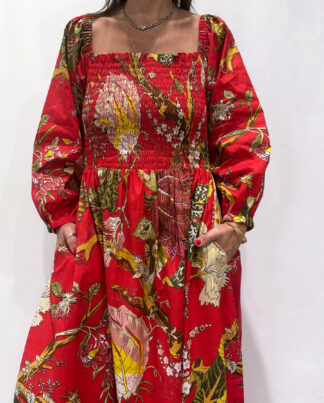 Robe Amira Rouge, une robe longue smockée. Fluide et 100 % coton. Elle est rouge avec des imprimée fleurit.