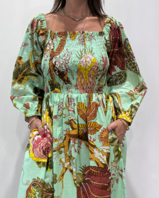 Robe Amira Vert D'eau, une robe longue smockée. Fluide et 100 % coton. Elle est de couleur vert d'eau avec des imprimée fleurit.