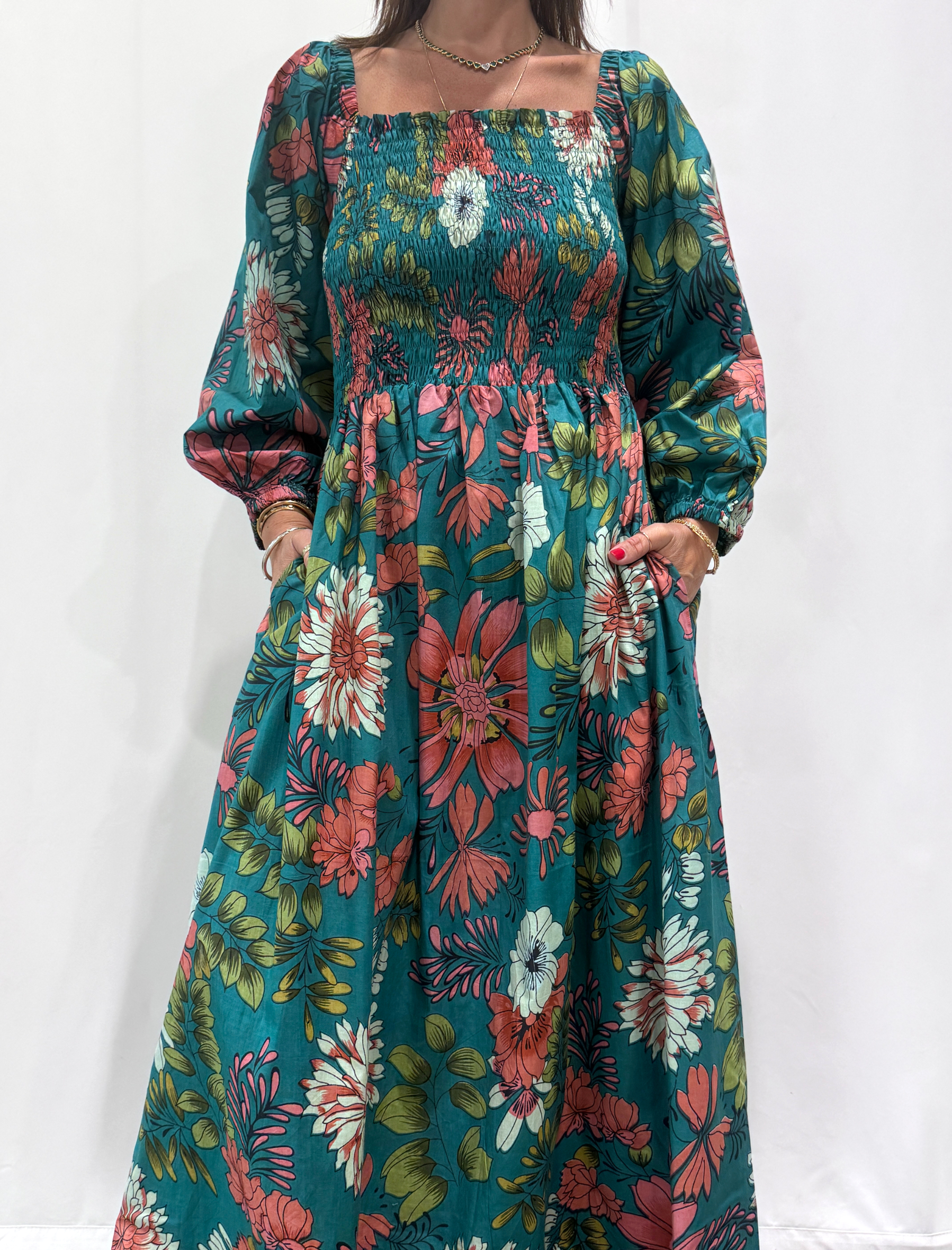 Robe Amira Bleue, une robe longue smockée. Fluide et 100 % coton. Elle est de couleur bleue avec des imprimée fleurit.