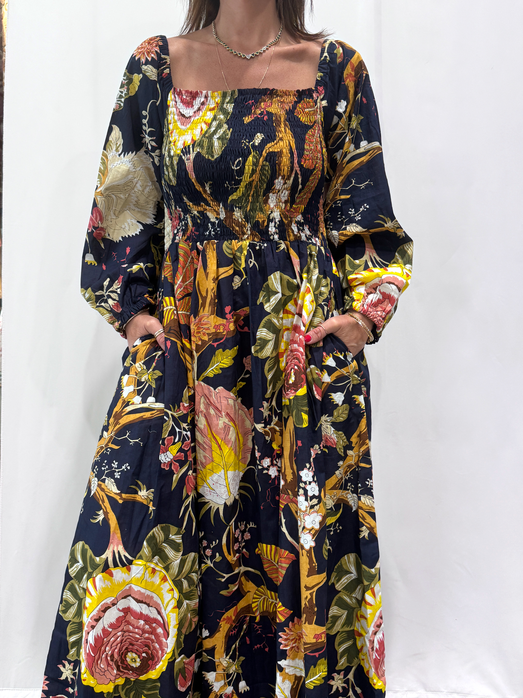 Robe Amira Bleue Marine une robe longue smockée. Fluide et 100 % coton. Elle est de couleur bleue marine avec des imprimée fleurit.