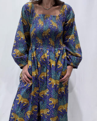 Robe Léora Bleu, une robe longue smockée. Fluide et 100 % coton. Elle est de couleur violette avec des imprimés de léopard.