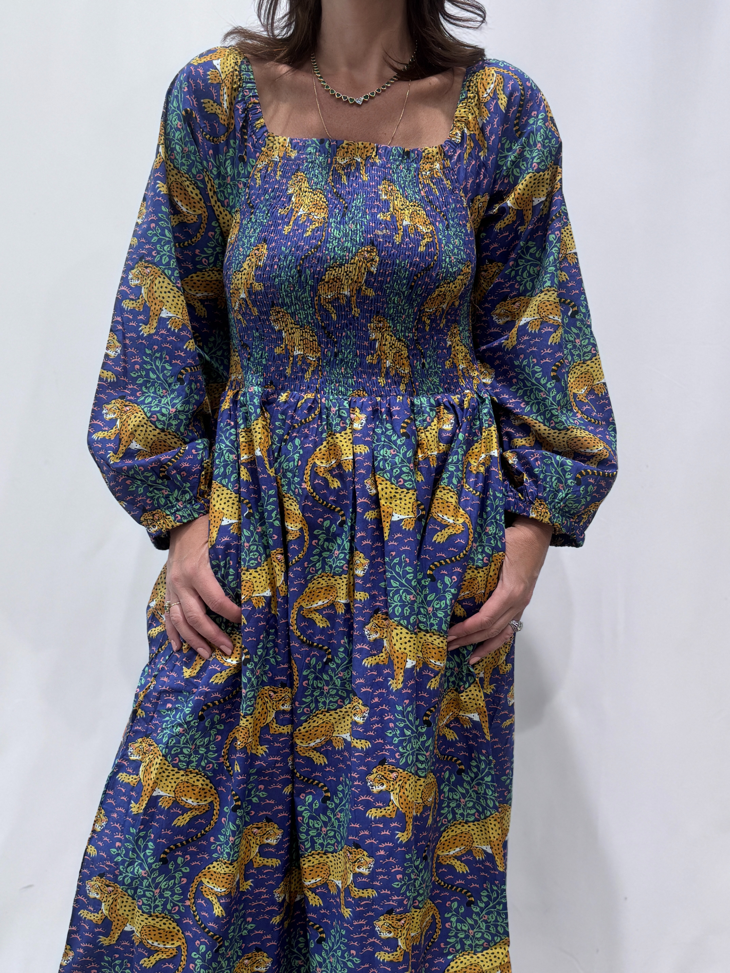 Robe Léora Bleu, une robe longue smockée. Fluide et 100 % coton. Elle est de couleur violette avec des imprimés de léopard.