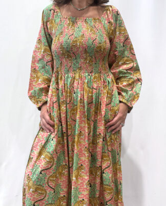 Robe Léora Rose, une robe longue smockée. Fluide et 100 % coton. Elle est de couleur rose avec des imprimés de léopard