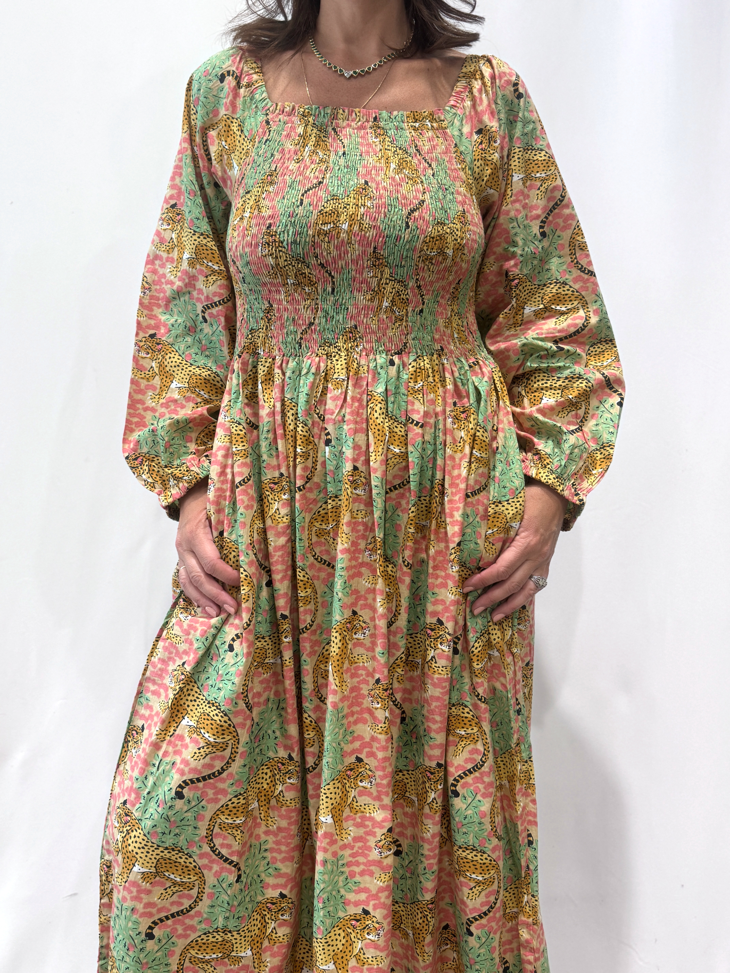 Robe Léora Rose, une robe longue smockée. Fluide et 100 % coton. Elle est de couleur rose avec des imprimés de léopard