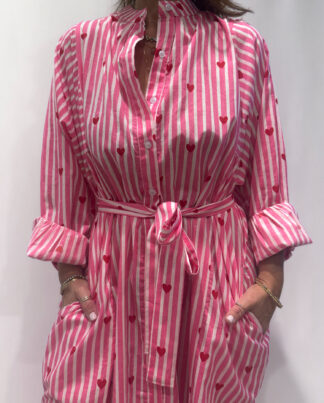 Robe Love Rose Pâle, une robe longue rayée rose pâle imprimé de coeurs rouges. Une robe taille unique qui se ceinture à la taille. Des manches longues.