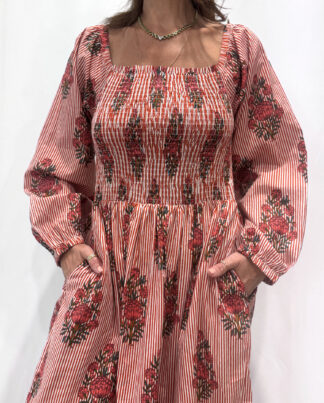 Robe Naya Bordeaux, une robe longue smockée. Fluide et 100 % coton. Elle est rayée avec des imprimés de fleurs.
