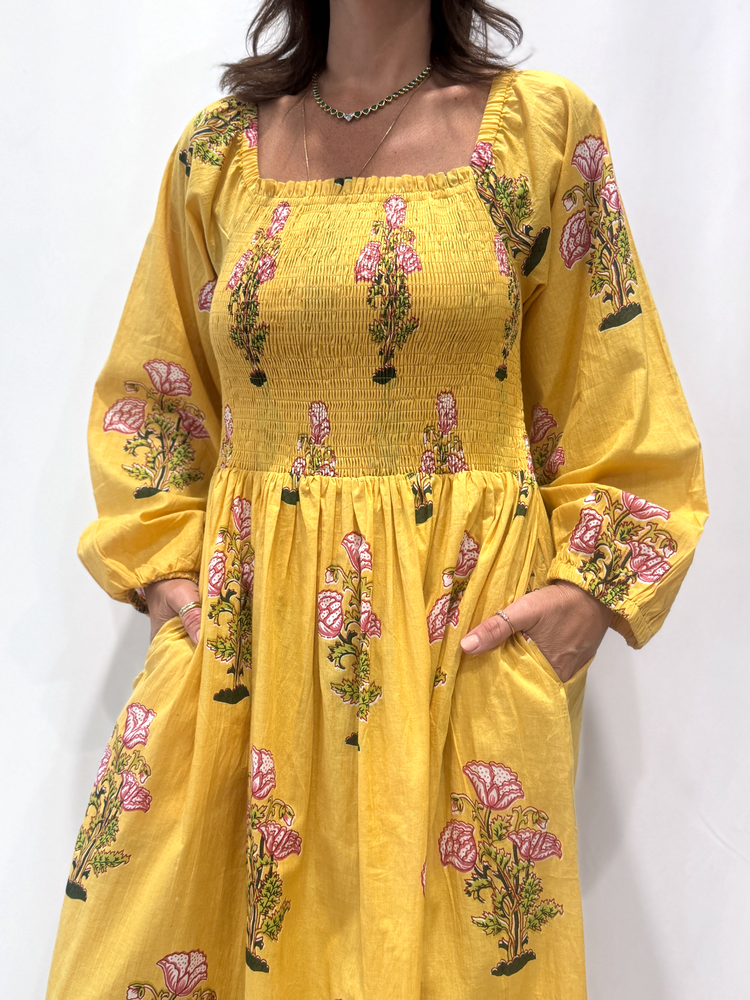 Robe Naya Jaune, une robe longue smockée. Fluide et 100 % coton. Elle est rayée avec des imprimés de fleurs.