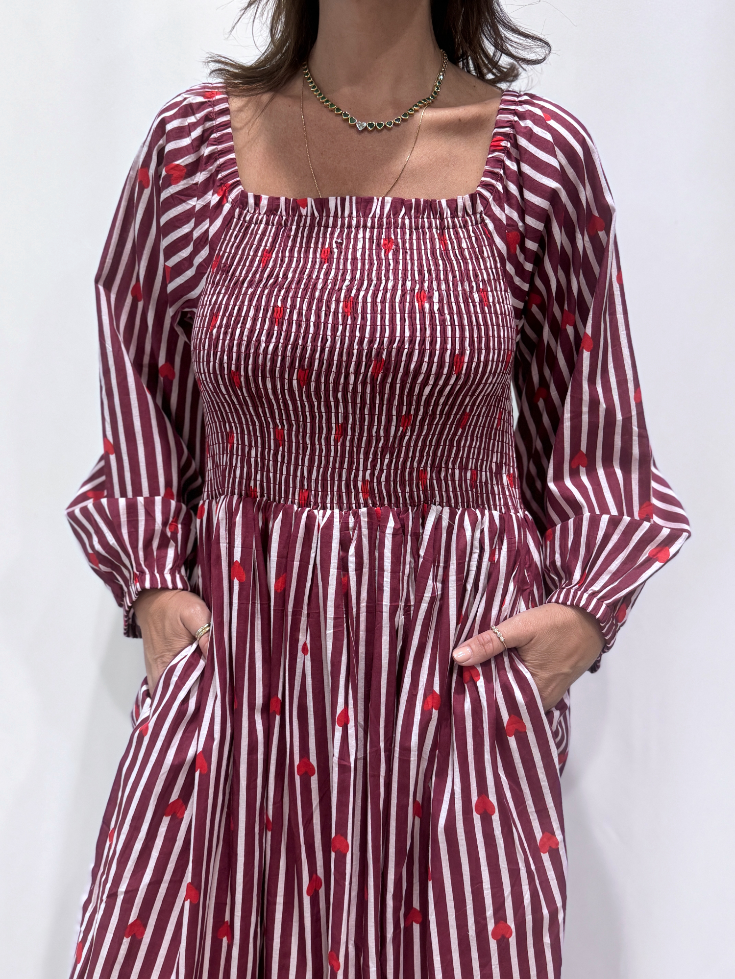 La robe Pyaar Bordeaux, une robe longue manches longues, smockée à rayures et imprimés de coeurs. Une robe tendance pour cet été.