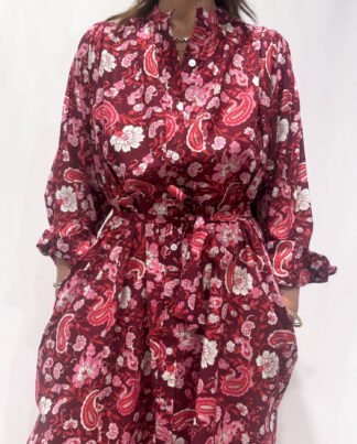Robe Upama Bordeaux, une robe longue avec des imprimés floraux. Une robe taille unique qui se ceinture à la taille. Des manches longues.