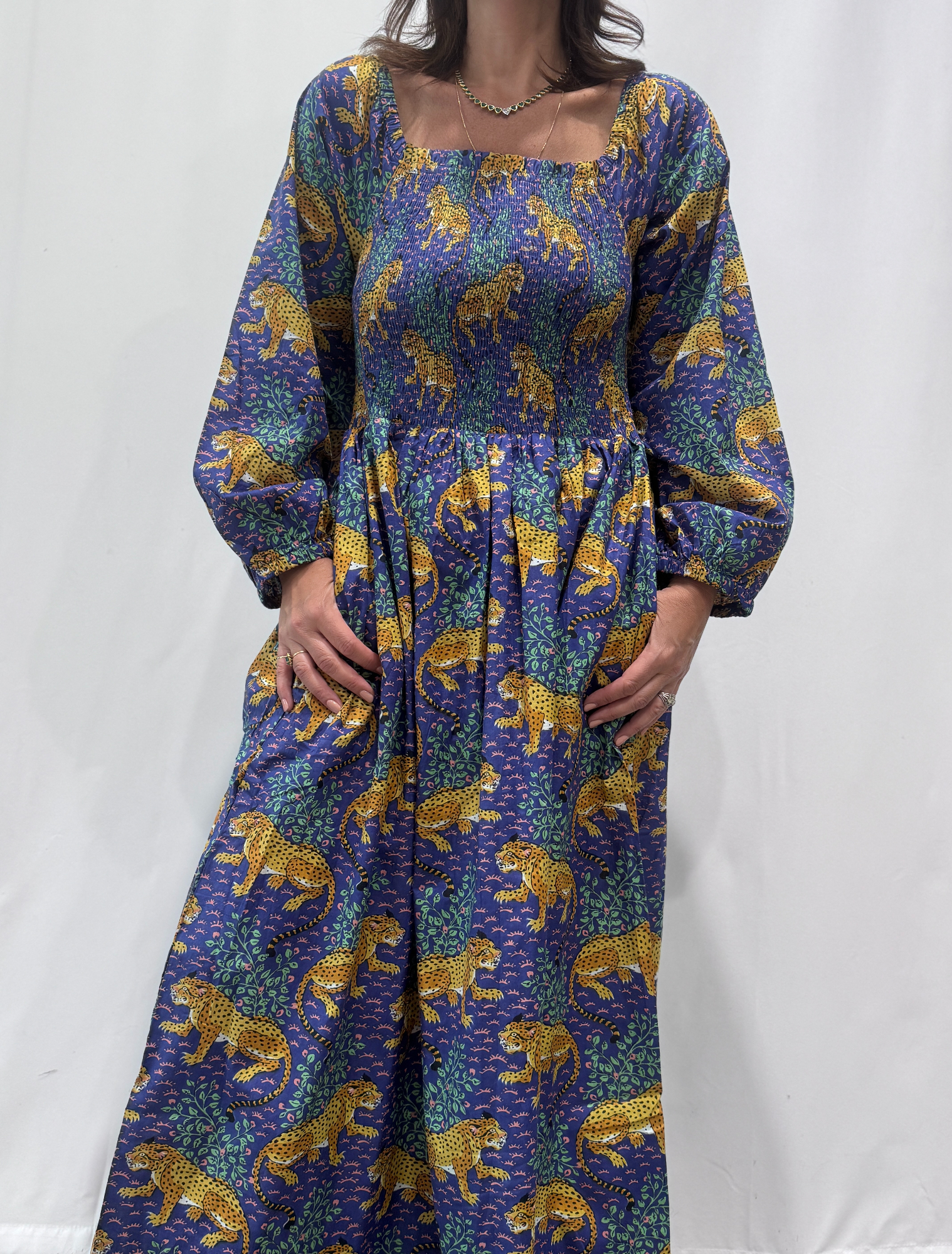 Robe Léora Bleu, une robe longue smockée. Fluide et 100 % coton. Elle est de couleur violette avec des imprimés de léopard.