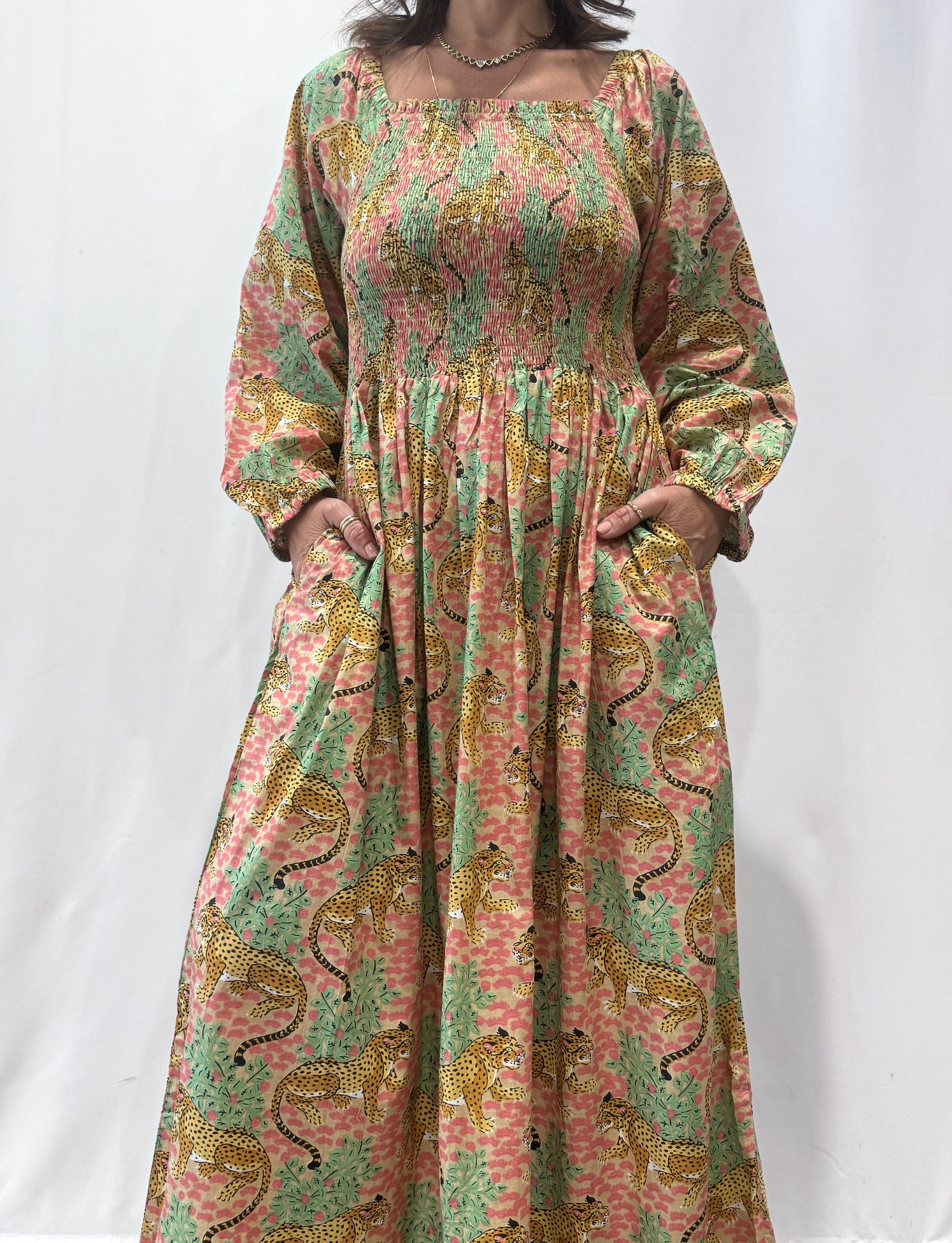 Robe Léora Rose, une robe longue smockée. Fluide et 100 % coton. Elle est de couleur rose avec des imprimés de léopard