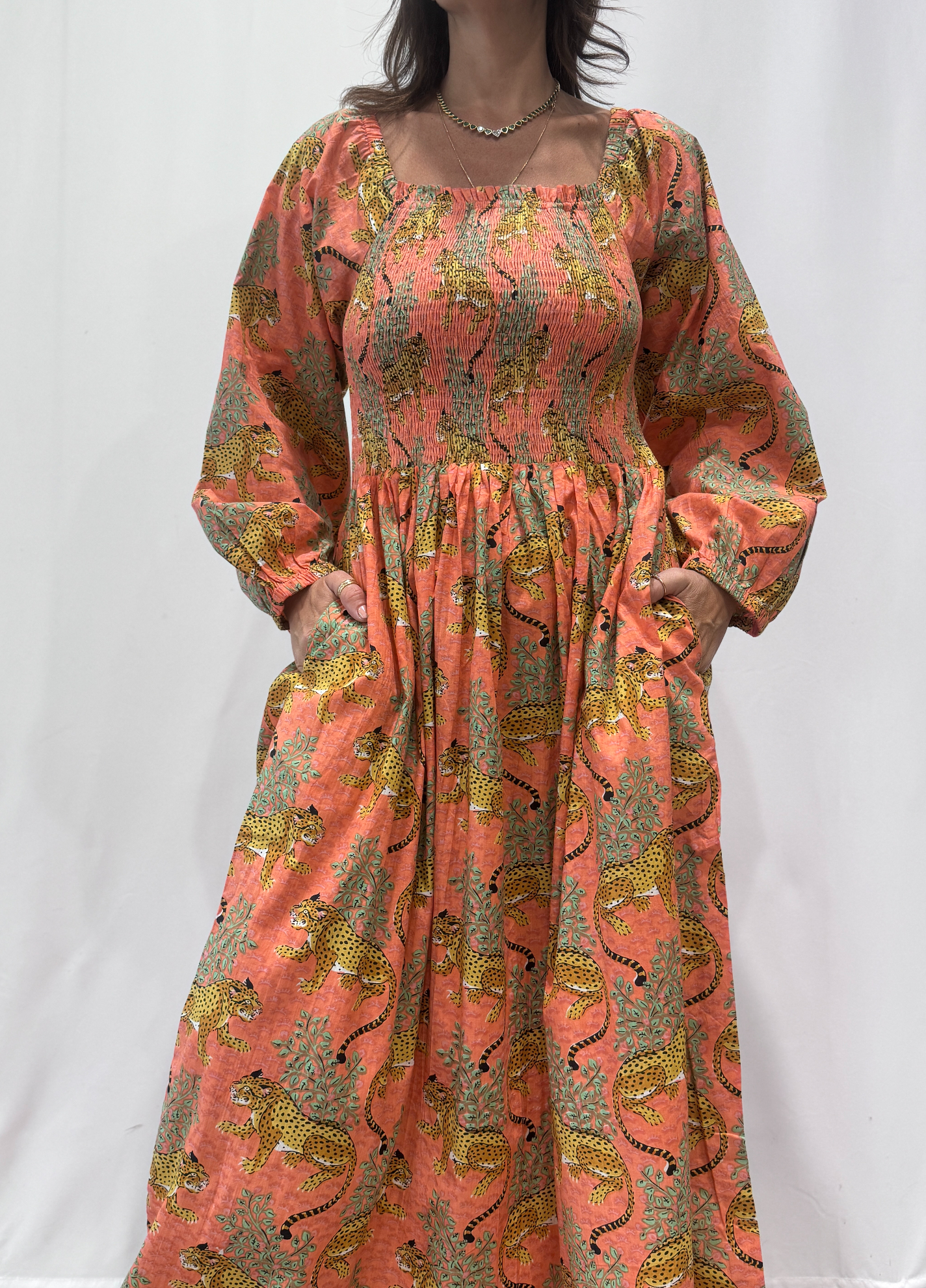 Robe Léora Saumon, une robe longue smockée. Fluide et 100 % coton. Elle est de couleur saumon avec des imprimés de léopard