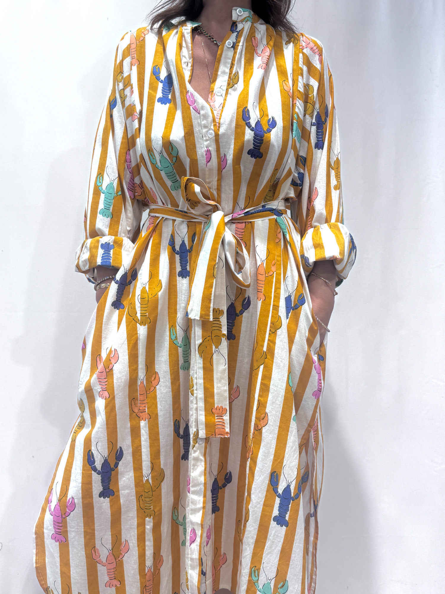 Robe Lobster Jaune, une robe longue rayée jaune. Une robe taille unique qui se ceinture à la taille. Des manches longues.
