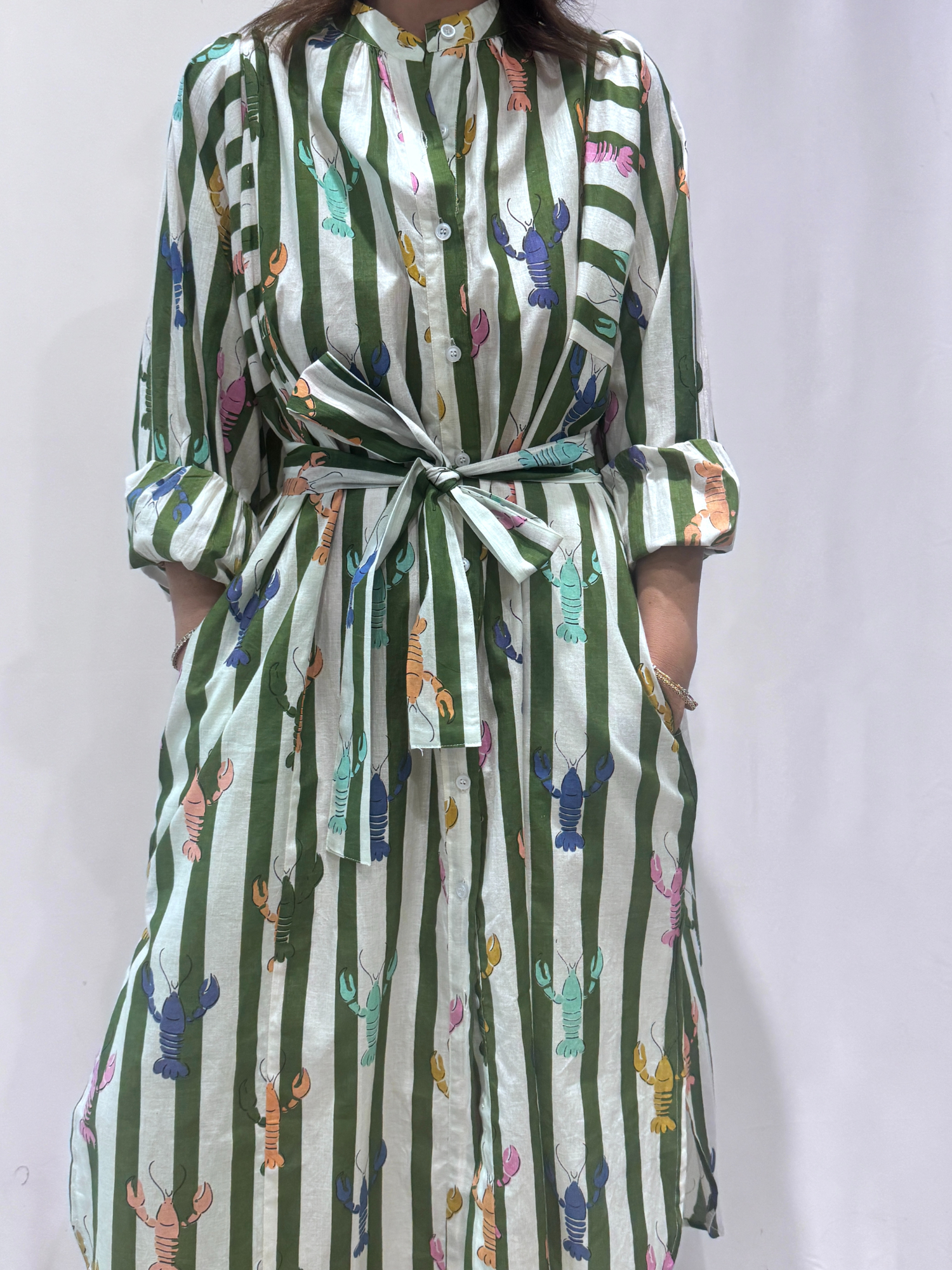 Robe Lobster Verte, une robe longue rayée verte. Une robe taille unique qui se ceinture à la taille. Des manches longues.