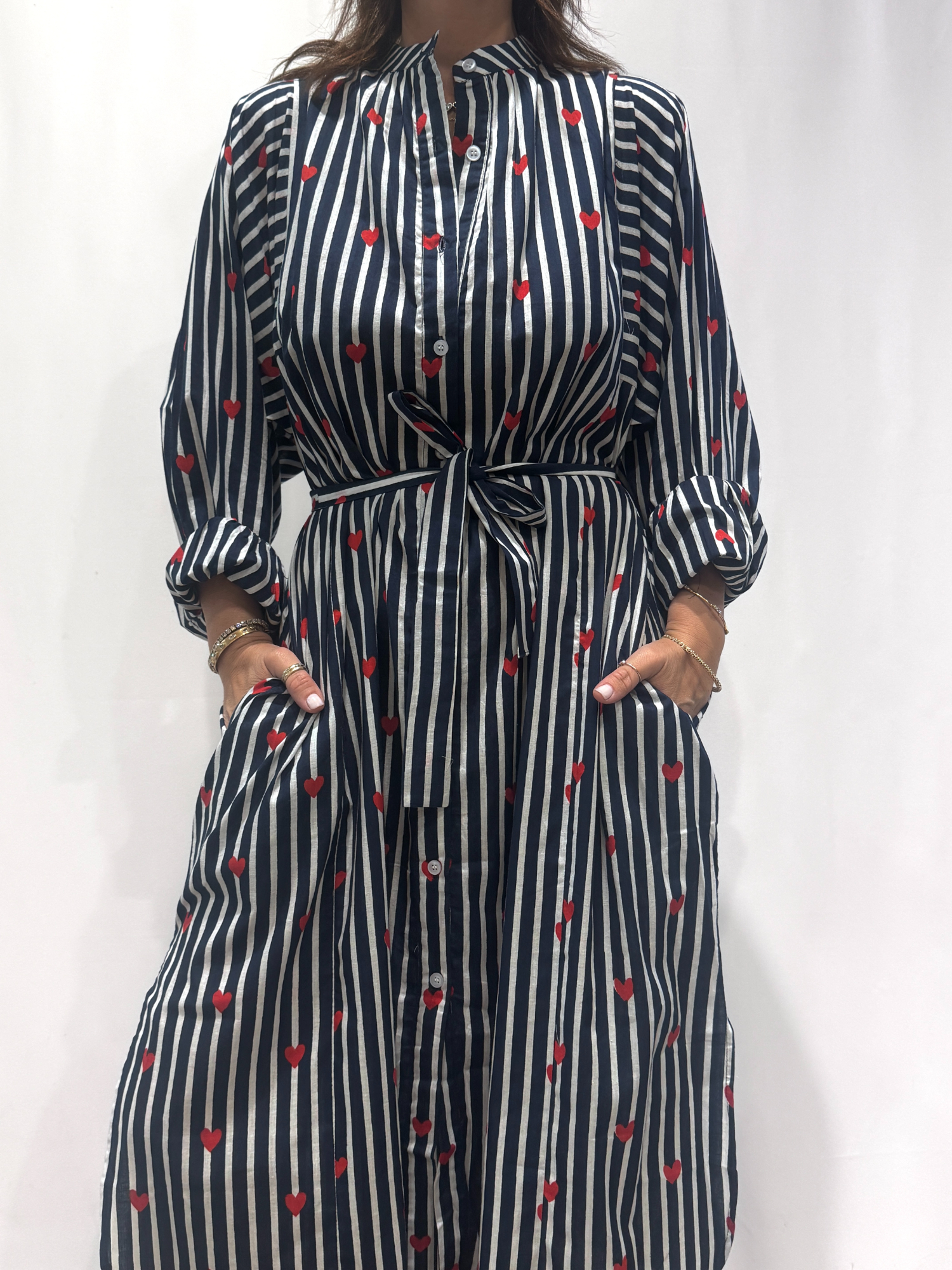 Robe Love Bleu, une robe longue rayée bleu imprimé de coeurs rouges. Une robe taille unique qui se ceinture à la taille. Des manches longues.