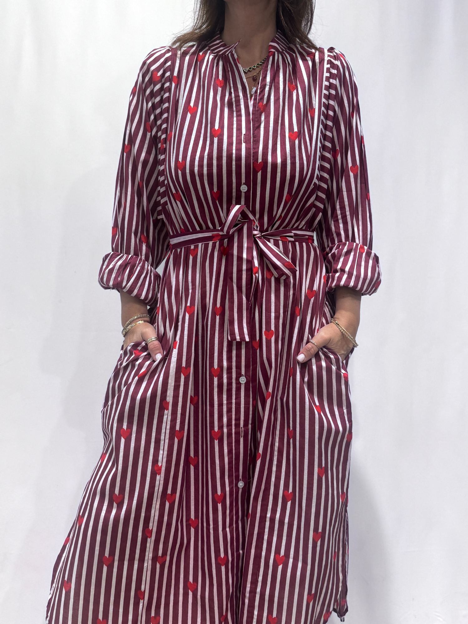 Robe Love Bordeaux, une robe longue rayée bordeaux imprimé de coeurs rouges. Une robe taille unique qui se ceinture à la taille. Des manches longues.