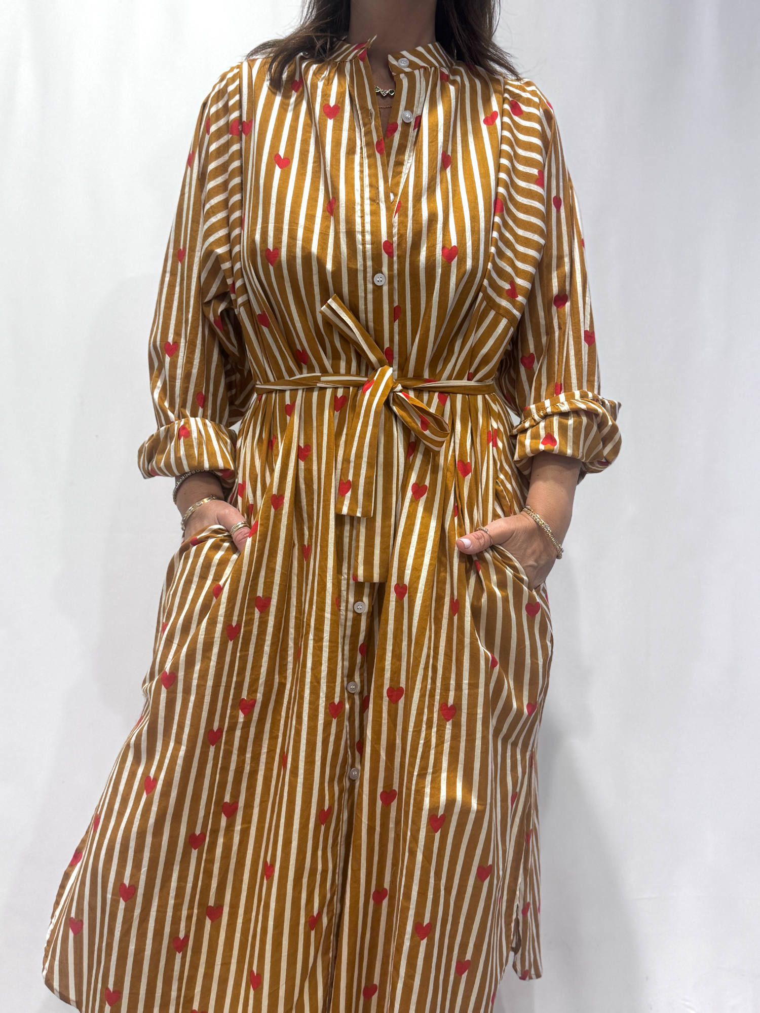 Robe Love Jaune, une robe longue rayée jaune imprimé de coeurs rouges. Une robe taille unique qui se ceinture à la taille. Des manches longues.