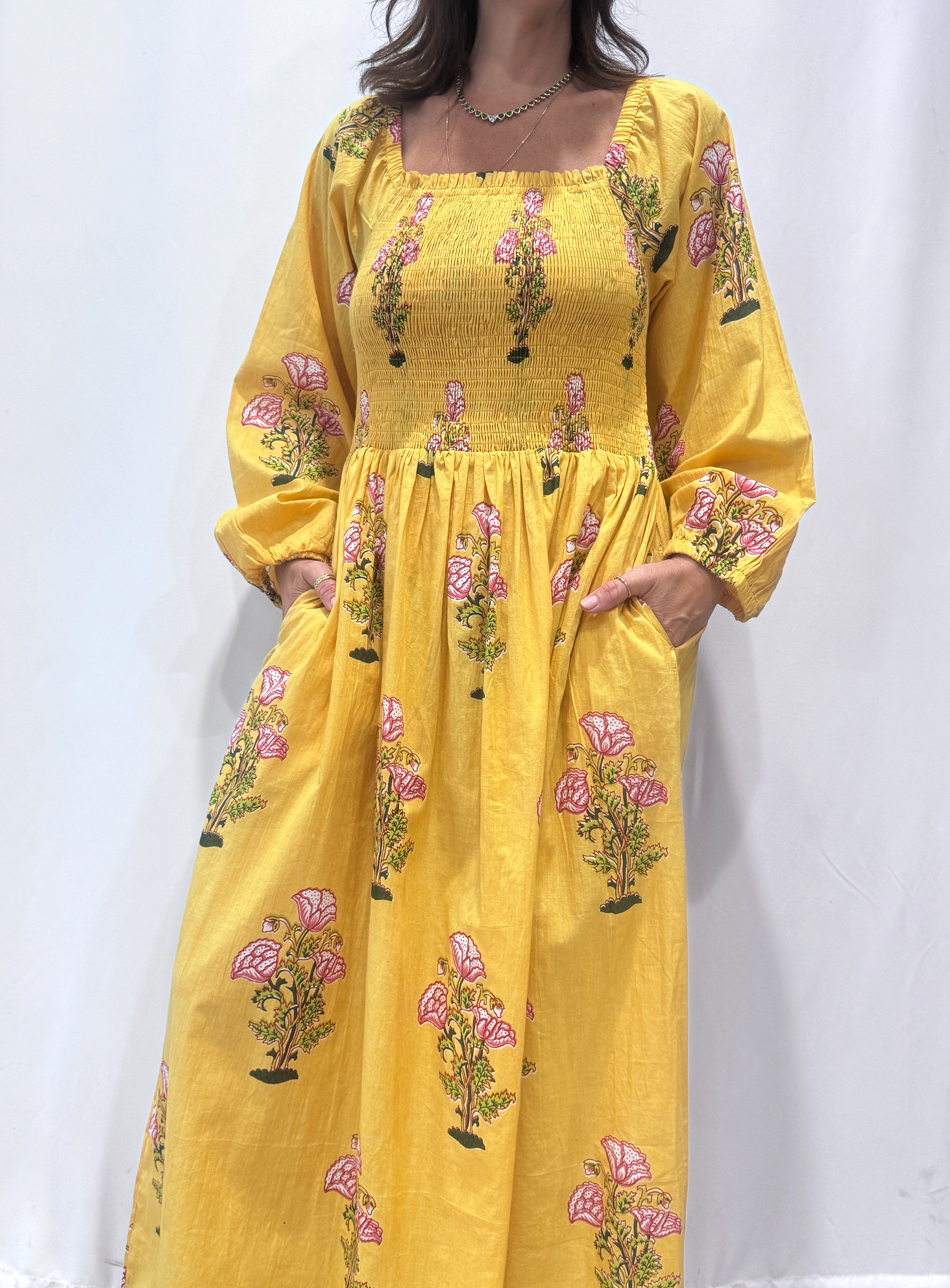 Robe Naya Jaune, une robe longue smockée. Fluide et 100 % coton. Elle est rayée avec des imprimés de fleurs.