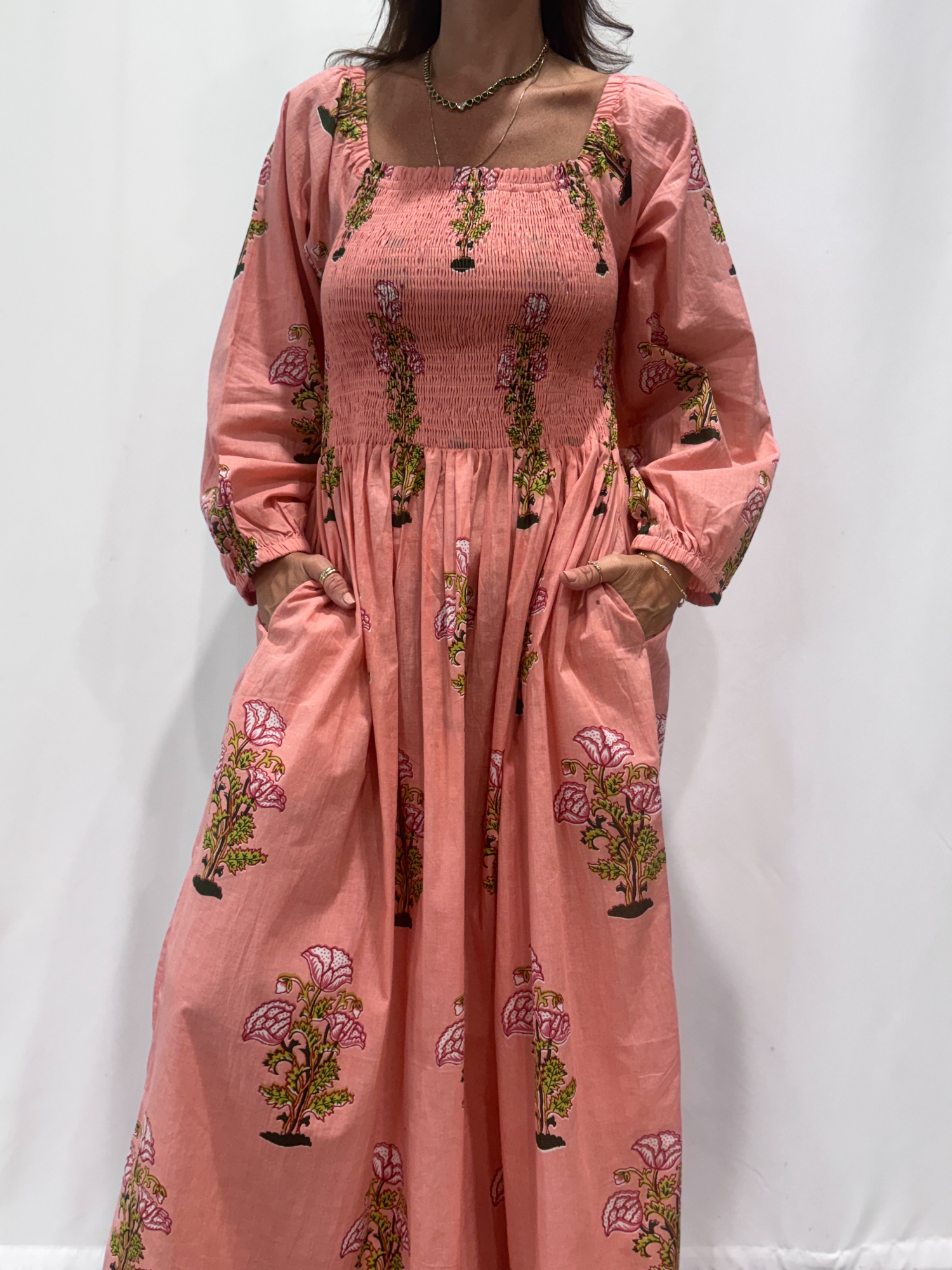 Robe Naya Rose, une robe longue smockée. Fluide et 100 % coton. Elle est rayée avec des imprimés de fleurs.