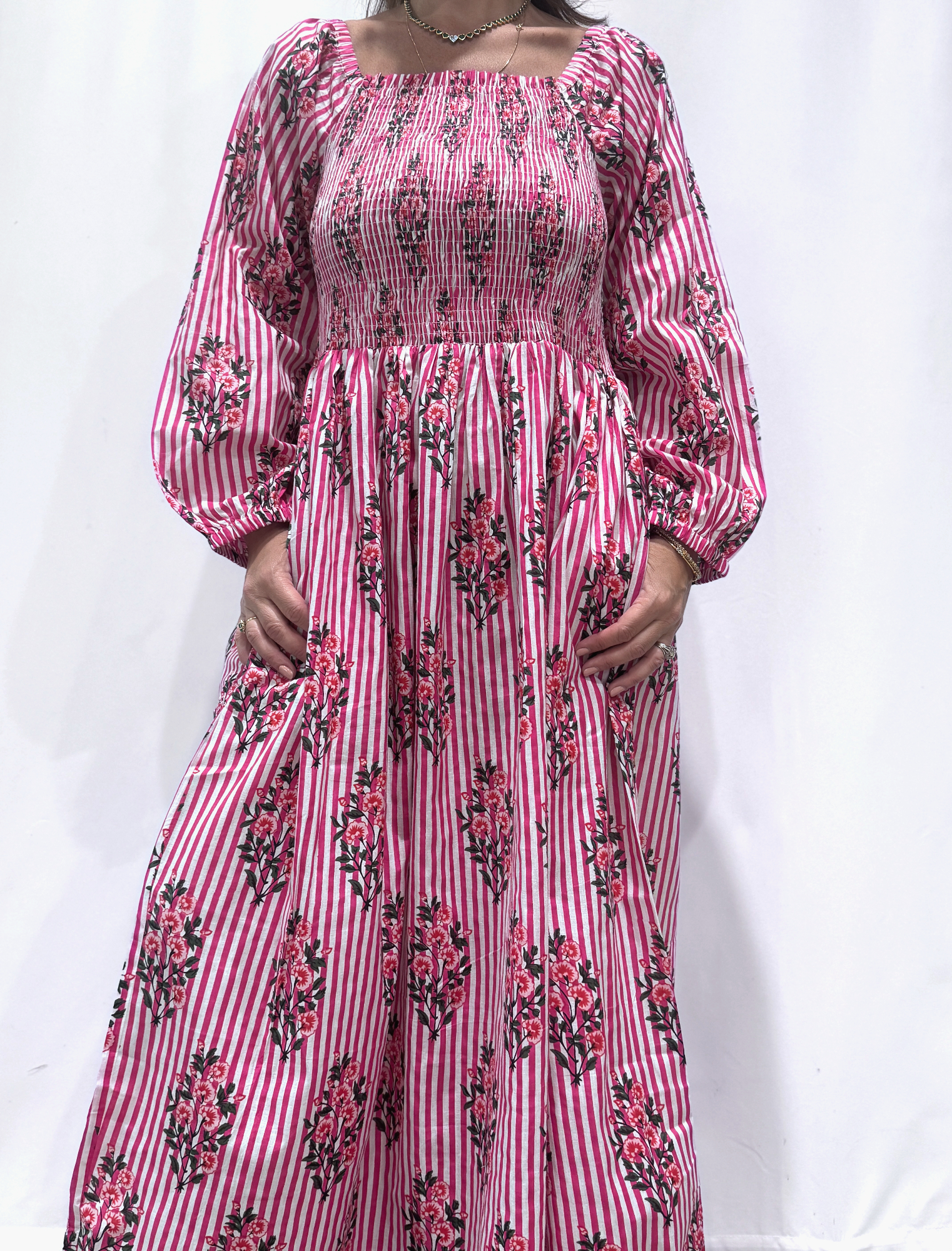 Robe Naya Rose Rayée, une robe longue smockée. Fluide et 100 % coton. Elle est rayée avec des imprimés de fleurs.