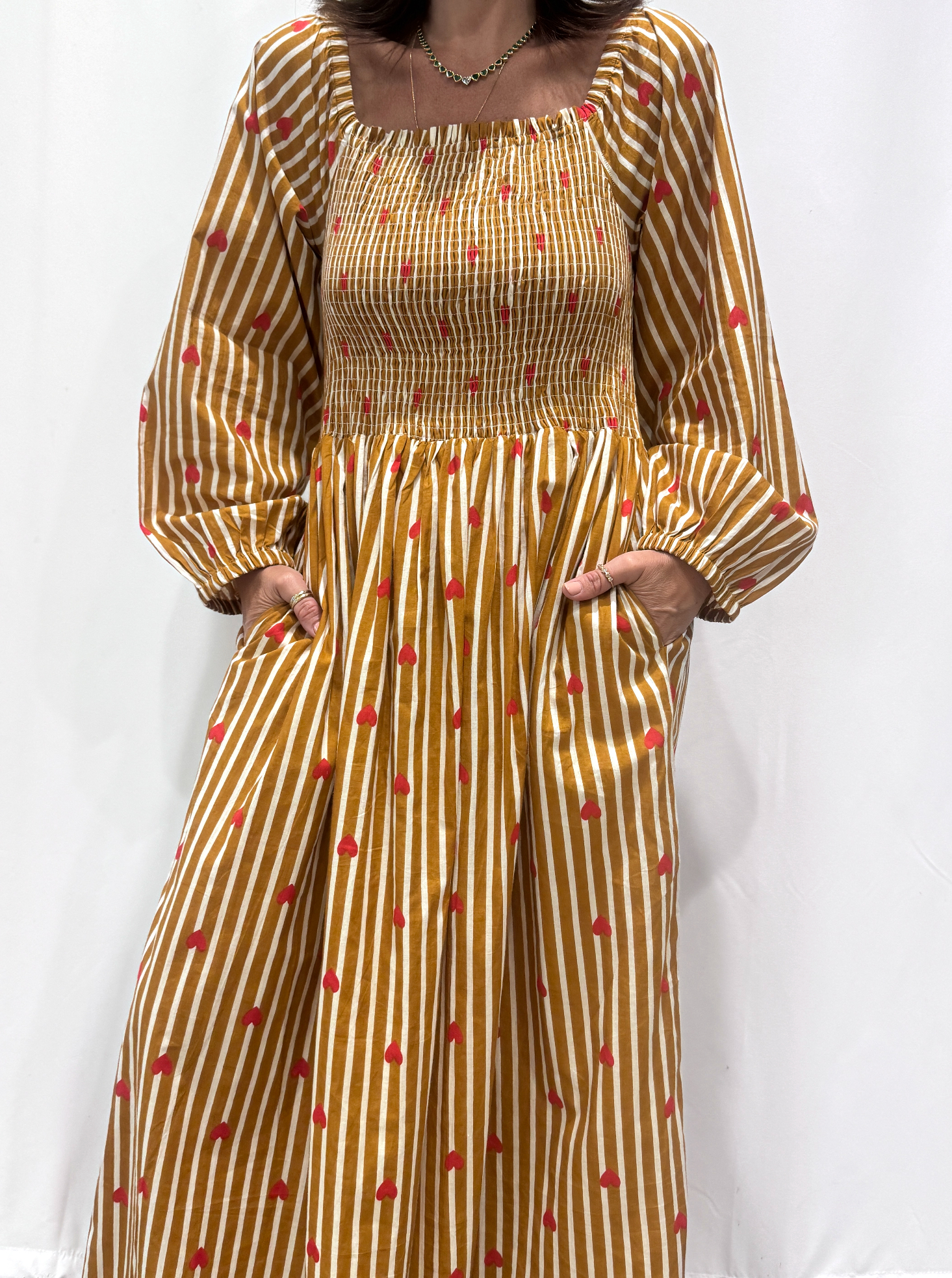 La robe Pyaar Jaune, une robe longue manches longues, smockée à rayures et imprimés de coeurs. Une robe tendance pour cet été.