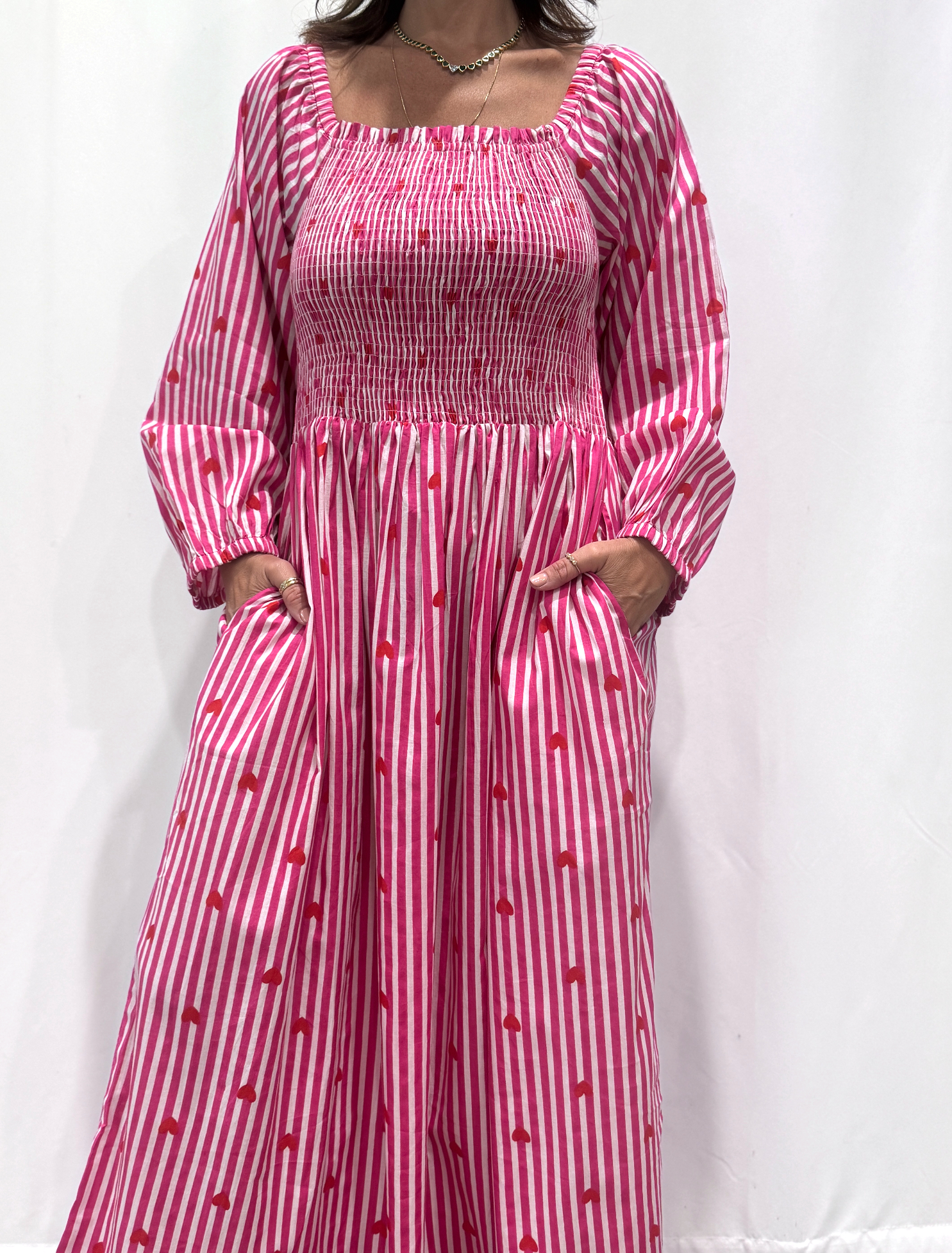 La robe Pyaar Rose, une robe longue manches longues, smockée à rayures et imprimés de coeurs. Une robe tendance pour cet été.
