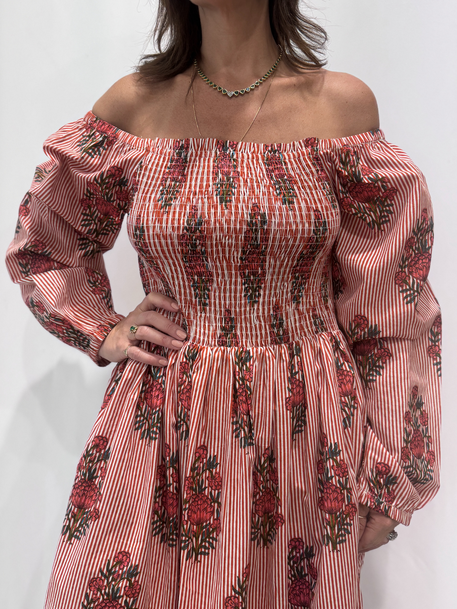Robe Naya Bordeaux, une robe longue smockée. Fluide et 100 % coton. Elle est rayée avec des imprimés de fleurs.