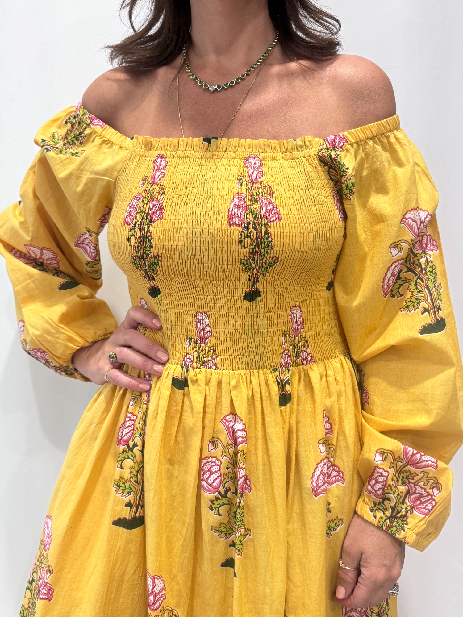 Robe Naya Jaune, une robe longue smockée. Fluide et 100 % coton. Elle est rayée avec des imprimés de fleurs.