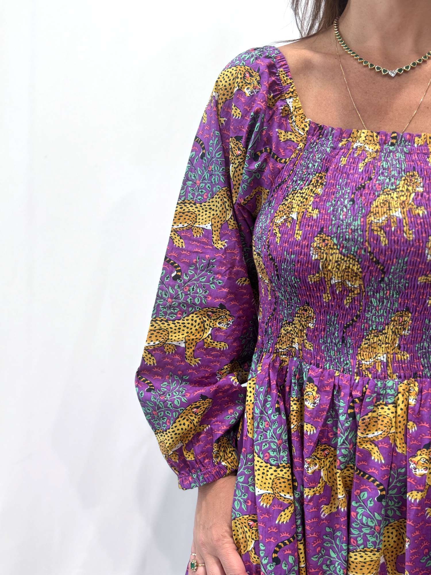 Robe Léora Violette, une robe longue smockée. Fluide et 100 % coton. Elle est de couleur violette avec des imprimés de léopard.